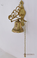 Dekoracyjny dzwonek mosiężny przed drzwi. Sklep z antykami.