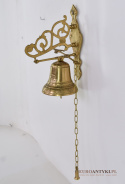 Dekoracyjny dzwonek mosiężny przed drzwi. Sklep z antykami.