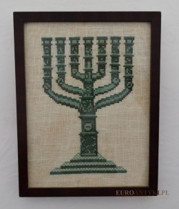 Stary obrazek z haftem menory żydowskiej. Menora