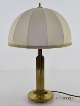 Retro lampa mosiężna z abażurem w gabinetowym klimacie.